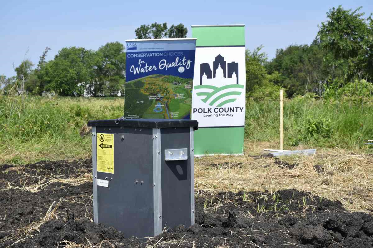 Saturated buffer in front of two signs promoting Polk County and water quality.