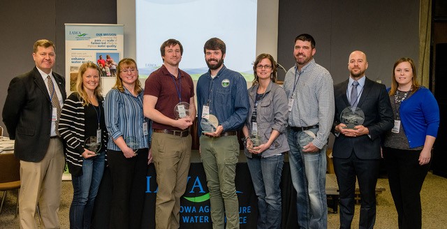 Photo: Sean McMahon, IAWA Executive Director, far left, and Jamie Benning, Water Quality Program Manager, Iowa State University Extension and Outreach, far right, with the 2018 IAWA Iowa Watershed Awards honorees. They include, left to right, Circle of Excellence honorees, Amanda Brown, Mindy Sieck, Colton Meyer, Shane Wulf, Velvet Buckingham, and Brian DeMoss, and 2018 Watershed Coordinator of the Year Lee Gravel. (Photo by Joseph L. Murphy, Iowa Soybean Association)
