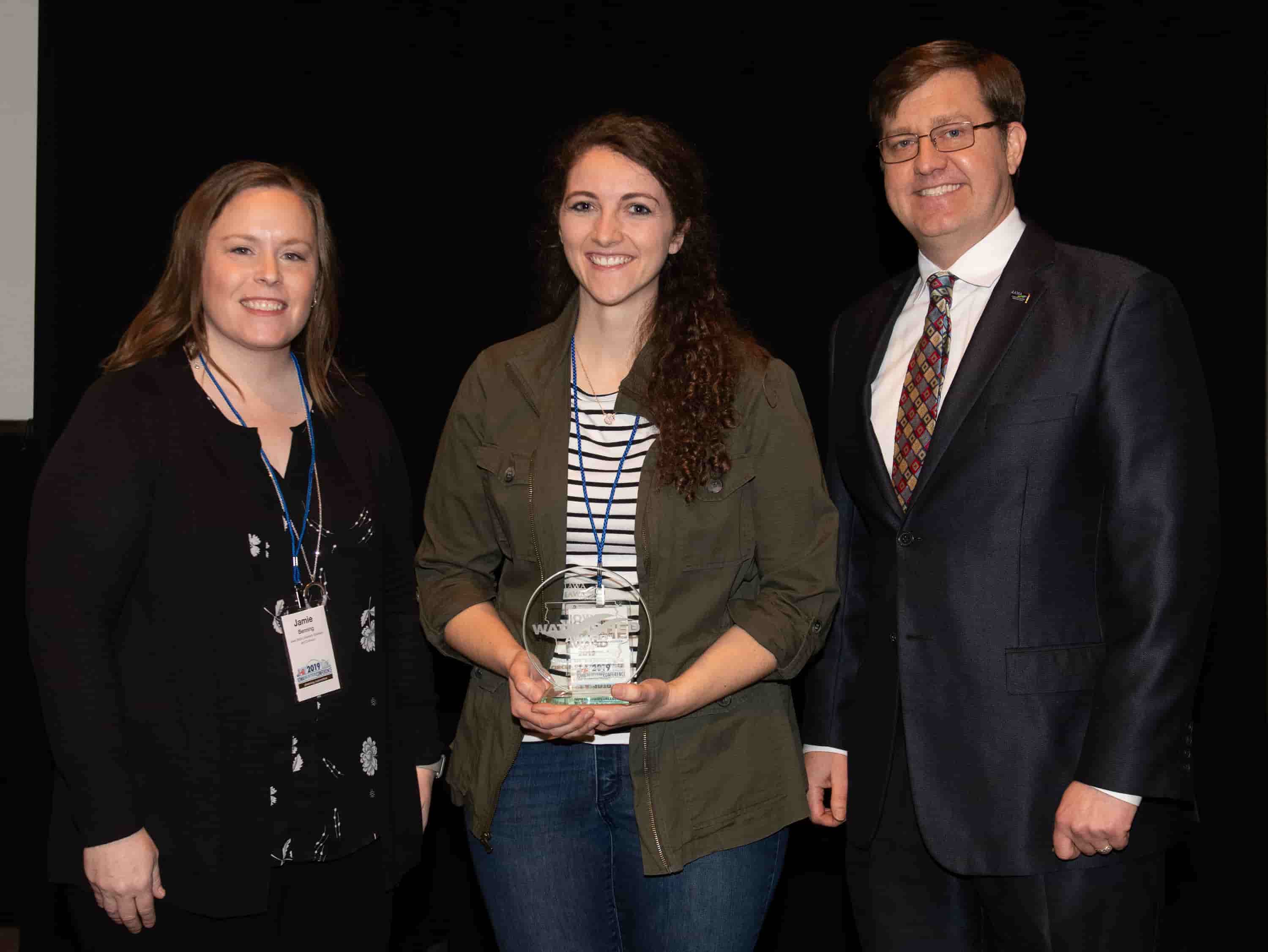 Jamie Benning with Iowa State University, Sean McMahon with Iowa Ag Water Alliance presenting Julie Perrault, watershed coordinator, with an IAWA Iowa Watershed Award