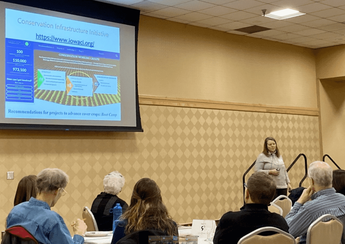 Sara Carlson speaks to a conference room of over one hundred farmers about cover crop farming.