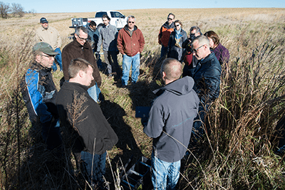 Iowa’s Water Future Task Force co-chairs Larry James and Steve Bruere and a host of others listen to ISA’s Keegan Kult explain how a bioreactor works to remove nitrates from water.