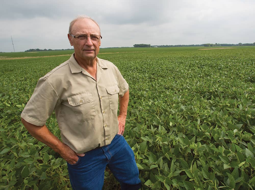 Wayne Fredericks , former Iowa Soybean President, stands in his field