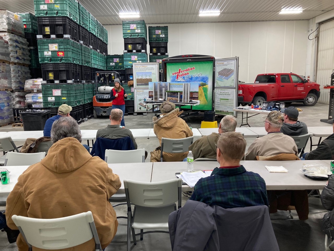 Conservation agronomist gives presentation to farmers sitting at tables